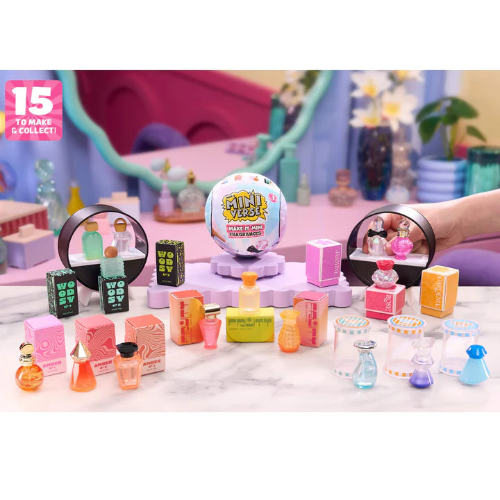 A large collection of assembled Miniverse Fragrance bottles, including Woody, Fruity, and Floral scent families, displayed with their matching boxes and the UV display stand.
