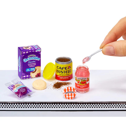 A breakfast themed miniature set showing a box of Smucker's Uncrustables, a tin of Cafe Bustelo espresso, and a jar of Smucker's Strawberry Jam being spooned out.