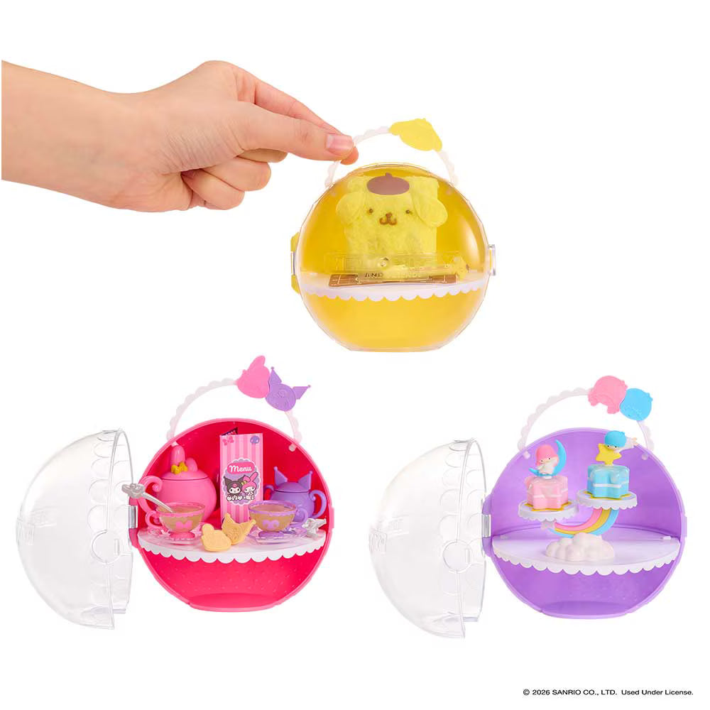 Three round translucent toy cases shown on a white background, with a human hand holding the top yellow case open. The cases contain miniature dollhouse-style accessories and are shown in yellow, pink, and purple colorways.