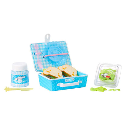 A miniature toy picnic set featuring a blue checkered lunchbox with sandwiches, a small jar of strawberry sauce, a green snack container, and accessories, displayed on a clean white background.