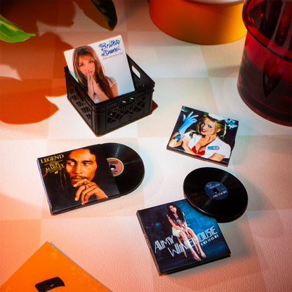 A hot pink mystery blind pack ball for MGA's Miniverse Real Music Vinyl surrounded by mini playable vinyl records, sleeves, and crates.