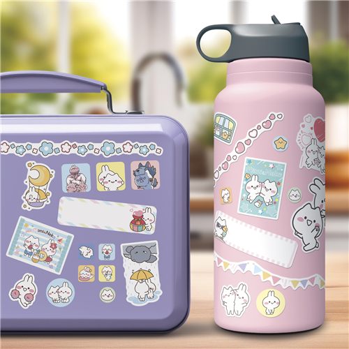 Purple lunch box and pink water bottle with cartoon designs on a blurred background