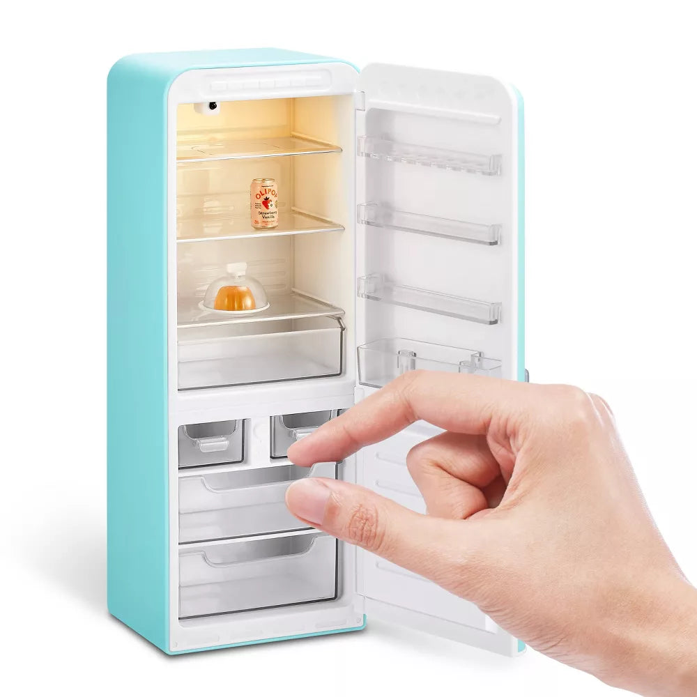 Small turquoise refrigerator with open door, hand reaching inside on a white background