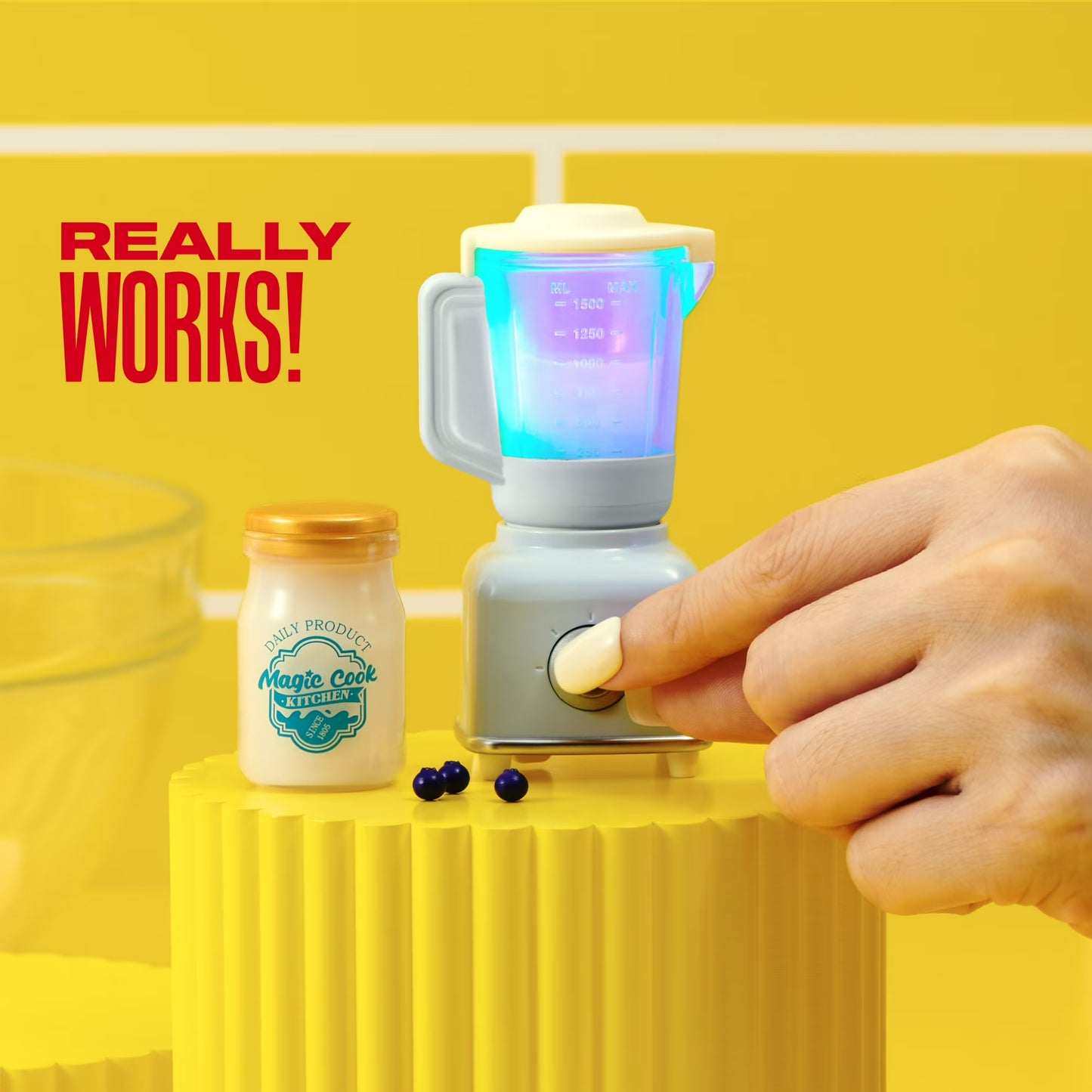 Small blender with colorful lights on a yellow background, next to a jar labeled 'Magic Cook'.