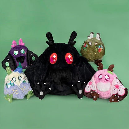 Four cute monster plush toys arranged together on a solid green background. The center is a large black monster with pink star eyes, flanked by a purple one with pink horns, an olive green one with bunny ears, and a pink one with brown antlers.