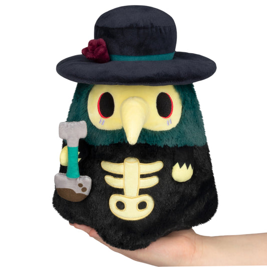 Mini Squishable Graveyard Plague Doctor plush with black cloak, rose hat, and shovel accessory
