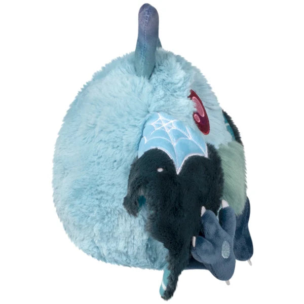 Mini Squishable Haunted Mothman plush featuring light blue fur, glowing red eyes, and dark tattered wings.