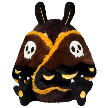Mini Squishable Hawkmothman plush featuring dark brown fur, yellow eyes, and dark wings with skull patterns.
