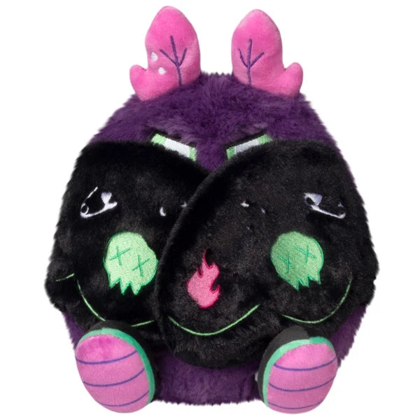 Mini Squishable Neon Punk Mothman plush with deep purple fur, neon pink antennae, bright green eyes, and patch-embellished black wings.
