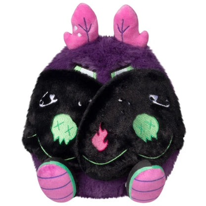 Mini Squishable Neon Punk Mothman plush with deep purple fur, neon pink antennae, bright green eyes, and patch-embellished black wings.