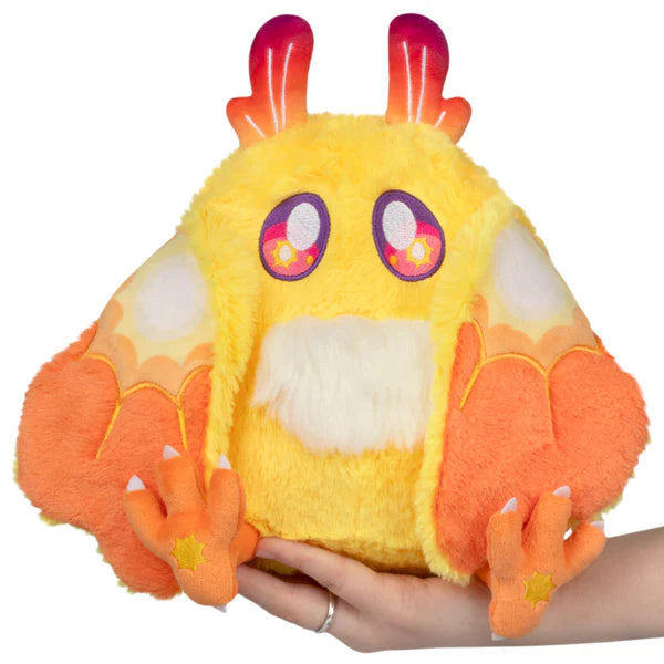 Mini Squishable Solar Mothman plush featuring bright yellow fur, orange wings, and red gradient antennae.