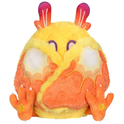 Mini Squishable Solar Mothman plush featuring bright yellow fur, orange wings, and red gradient antennae.