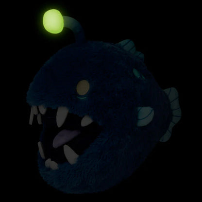 Glowing blue creature head with a green orb on a black background