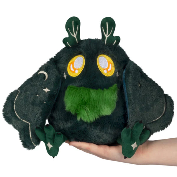 Squishable Mini Dark Forest Mothman 9-Inch Plush, a dark green cryptid soft toy with bright green chest fluff and starry forest pattern wings