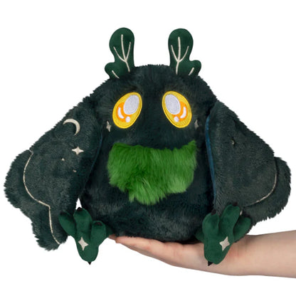 Squishable Mini Dark Forest Mothman 9-Inch Plush, a dark green cryptid soft toy with bright green chest fluff and starry forest pattern wings