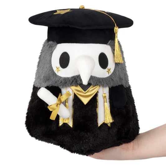 Squishable Mini Graduation Plague Doctor 10-Inch Plush, a black and dark grey soft toy with a white mask, gold accents, a graduation cap, and a diploma