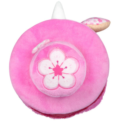 Squishable Mini Sakura Plague Doctor 10-Inch Plush, a vibrant pink and magenta soft toy with a floral fan and cherry blossom accents
