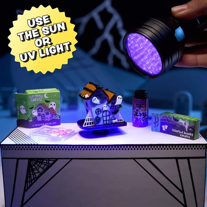 Halloween-themed items on a table with a UV light illuminating them. Miniverse Make it Mini Halloween Series 3.