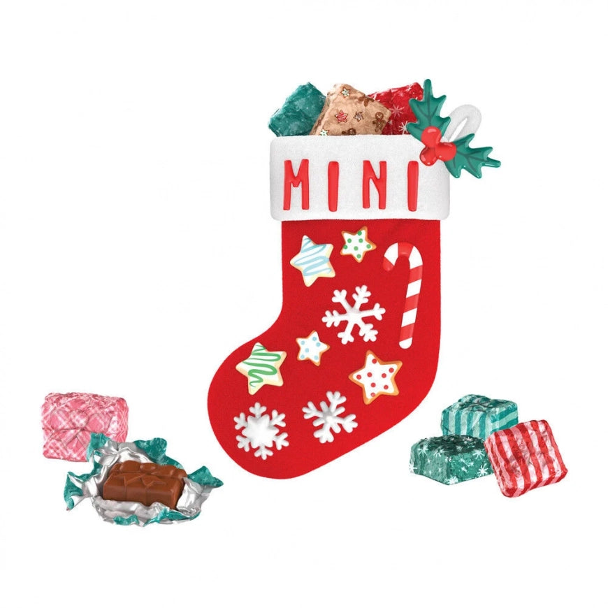 A red Christmas stocking with white trim and the word "MINI" on the cuff, filled with wrapped candies and surrounded by a few loose wrapped candies on a plain white background.