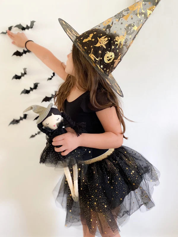 Mon Ami Cassandra Witch Doll wearing a black star-glitter tulle cape, metallic witch hat, and silver shoes.