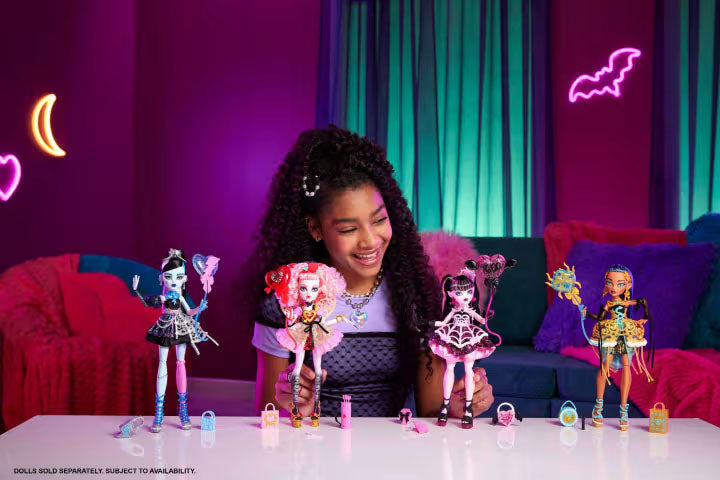 Girl playing with Monster High dolls in a colorful room