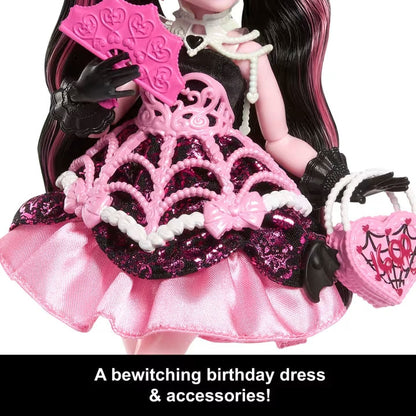 Doll in a pink and black birthday dress with accessories on a white background