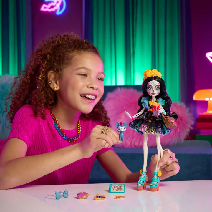 Monster High Skelita Calaveras fashion doll wearing a colorful papel picado dress alongside her pet xolo dog Candelita.
