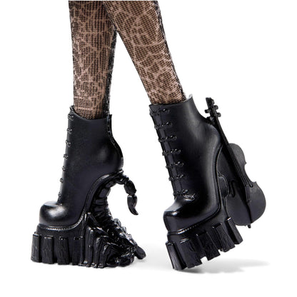 Black platform boots with unique sole design worn by a person.