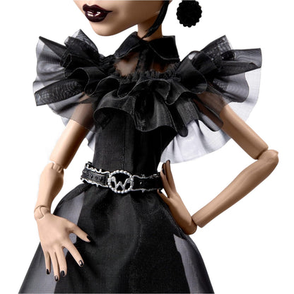 Doll wearing a black dress with ruffled collar and white top on a white background