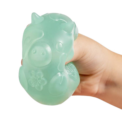 Hand holding a green jade Mushikins Squishy Toy against a white background