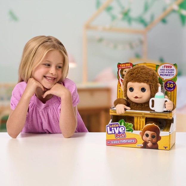 Little Live Pets My Baby Monkey Mango interactive plush toy Canada beside girl on table