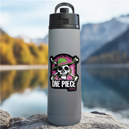Gray water bottle with 'One Piece' design on a rock by a lake with mountains in the background