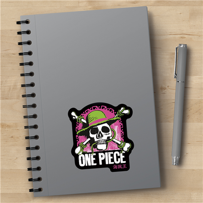 Gray notebook with 'One Piece' design and a pen on a wooden surface