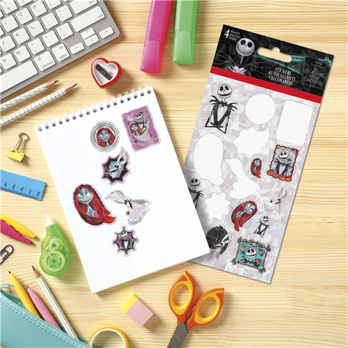 Sheet of stickers with cartoon characters on a desk with stationery items