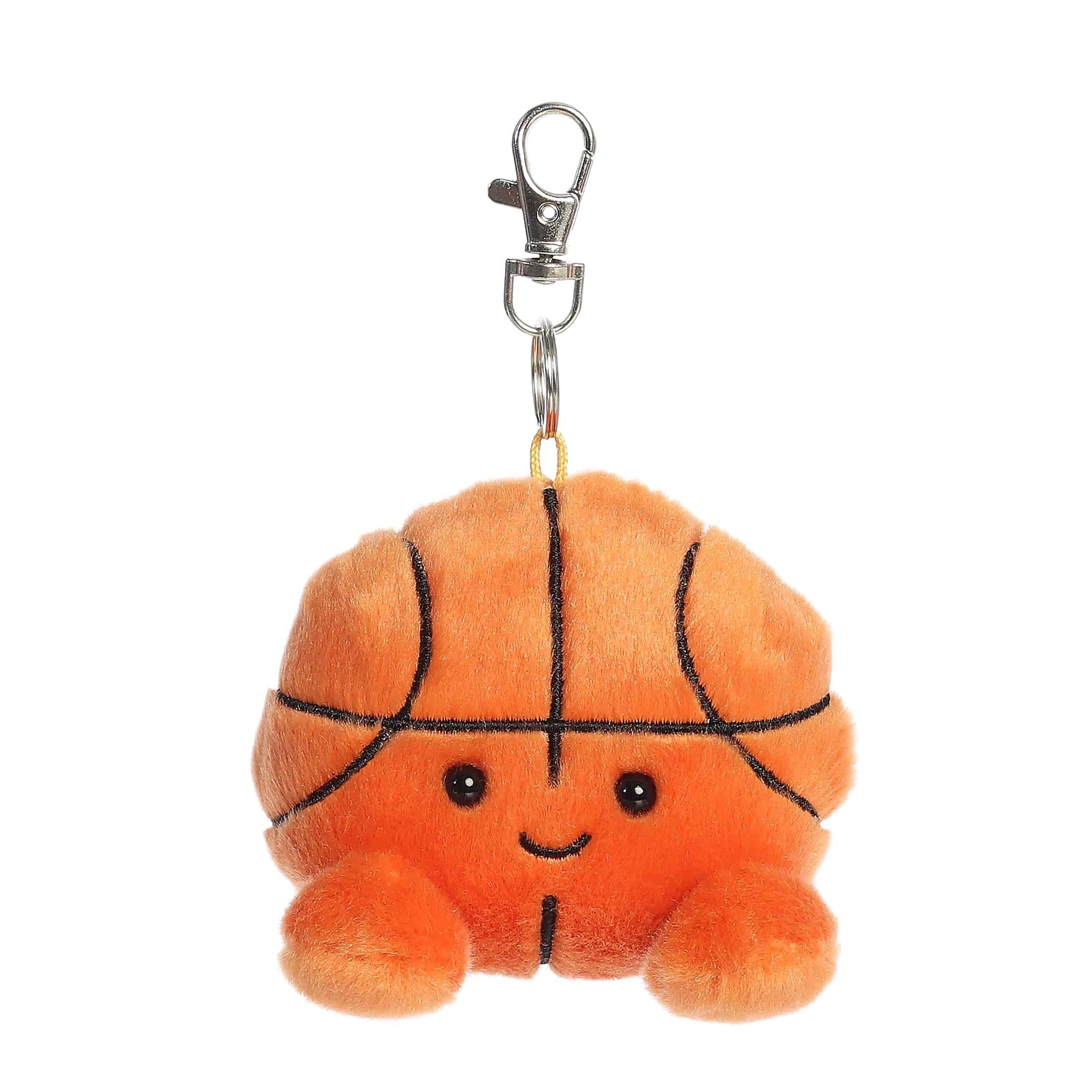 Product view of Palm Pals Hoops Basketball, a 4-inch round plush basketball with a smiling face and orange feet, featuring a plastic keychain clip.