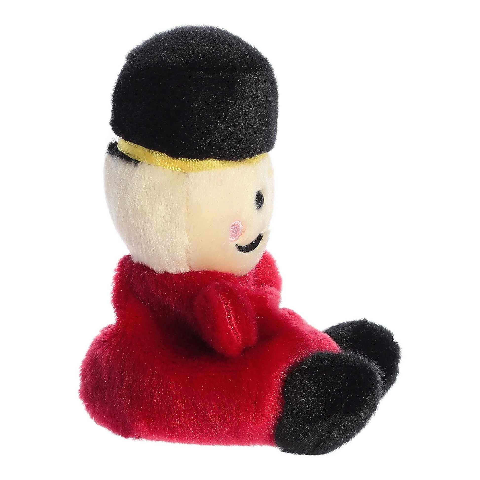 Palm Pals Marius Nutcracker plush featuring a red uniform with gold details, black boots, a black mustache, and a tall black fur hat.