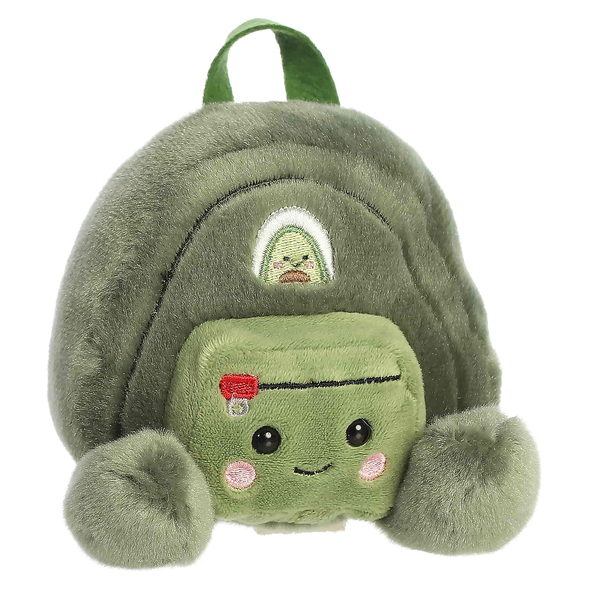 Palm Pals Rainier Backpack, a small green plush shaped like a backpack with a cute blushing face and an avocado patch.