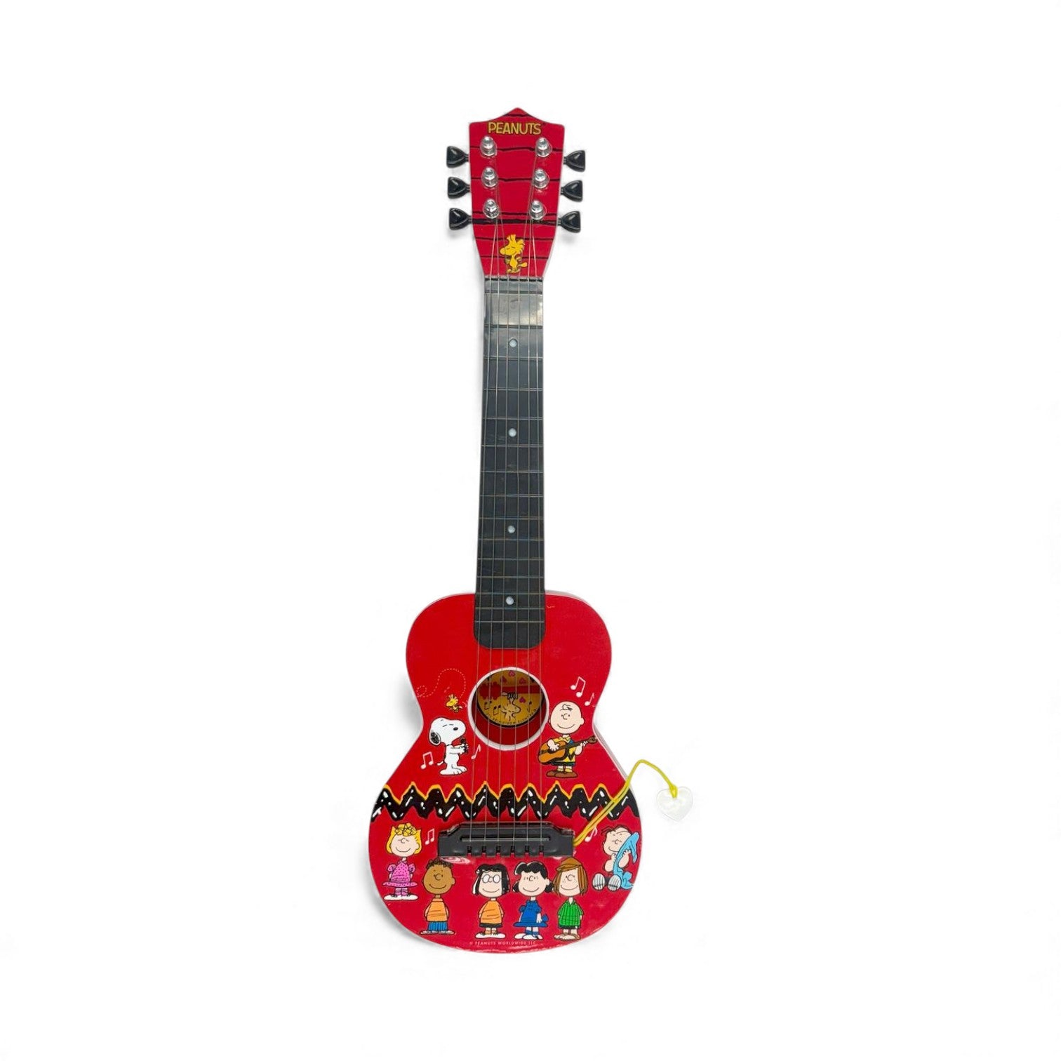 Product view of the Peanuts 21-Inch Guitar, a red acoustic-style guitar for
kids featuring Snoopy, Charlie Brown, and friends with an attached heart pick.