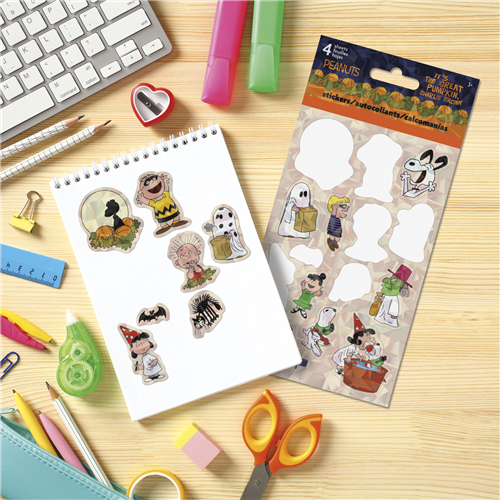 Sticker sheet with cartoon characters on a desk with stationery items