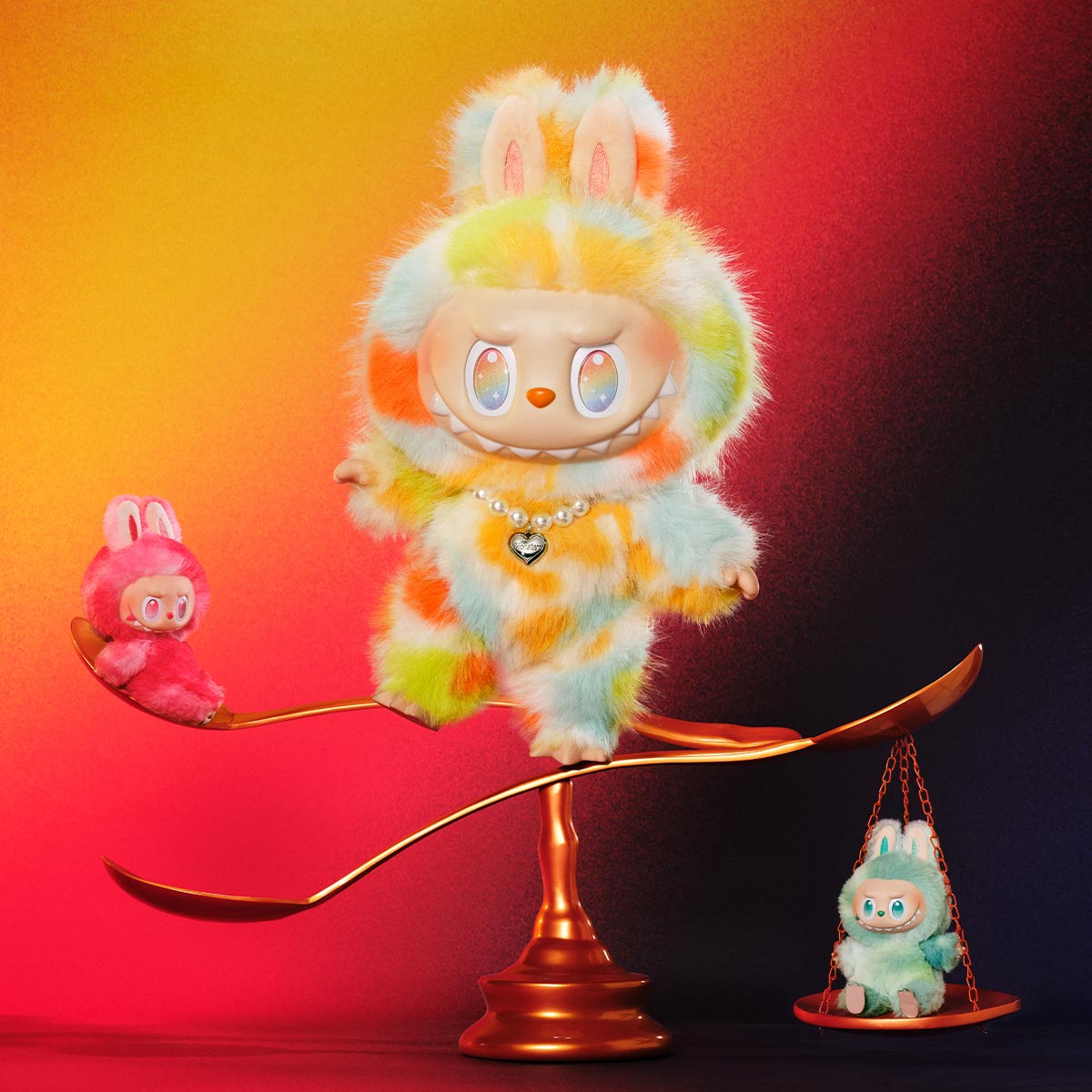 Colorful plush toy on a balance scale with smaller toys on either side against a gradient background