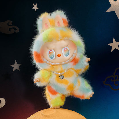 A product photo of the POP MART "Rock the Universe" Labubu, a large 14.57-inch vinyl plush doll with rainbow tie-dye fur and a pearl heart necklace on a starry night background.