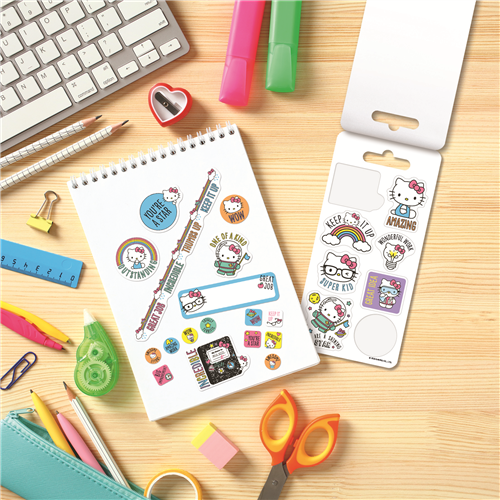Hello Kitty-themed stationery items on a wooden surface with a keyboard and office supplies.