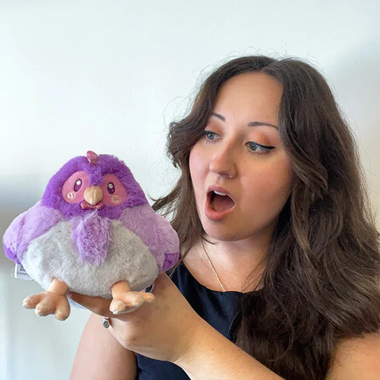 Woman holding a Squishable Party Snacker Purple Hen 6-Inch Plush