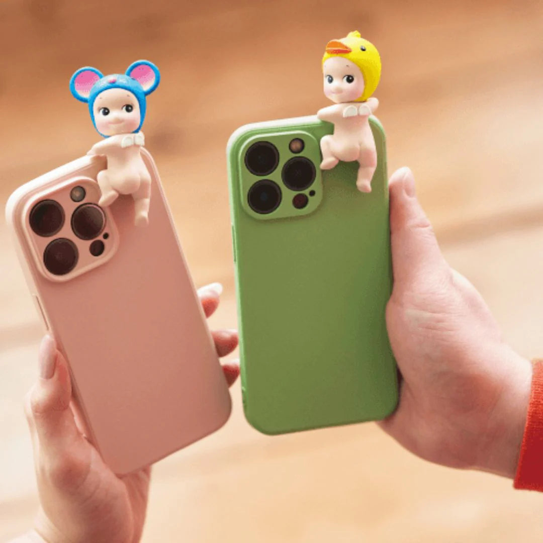 Two phone cases with cute figurines on a beige background