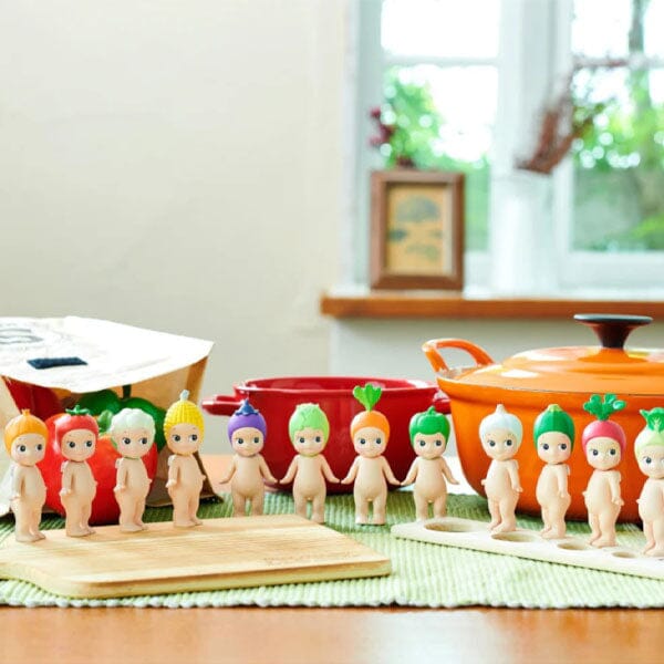 Set of small figurines resembling babies with colorful hair and outfits on a kitchen counter.