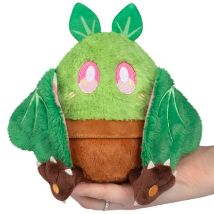 Squishable Alter Egos Series 21 Plant Mothman plush sitting in a plush brown flowerpot with bright green fur, leafy antennae, and leafy wings.