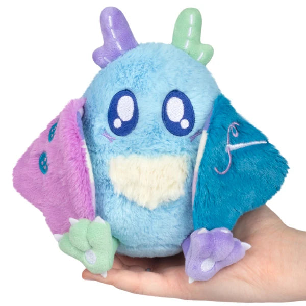 Squishable Alter Egos Series 21 Quilted Mothman plush with sky blue fur, mismatched antennae, and patchwork quilted wings.