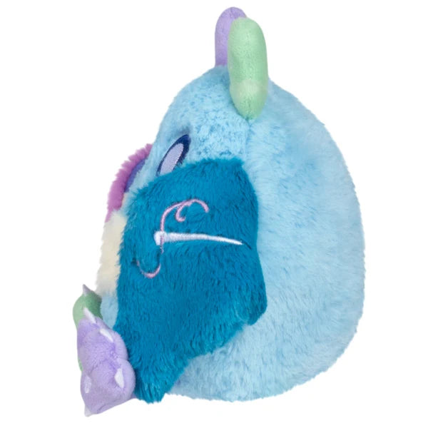 Squishable Alter Egos Series 21 Quilted Mothman plush with sky blue fur, mismatched antennae, and patchwork quilted wings.
