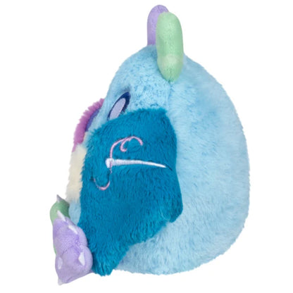 Squishable Alter Egos Series 21 Quilted Mothman plush with sky blue fur, mismatched antennae, and patchwork quilted wings.