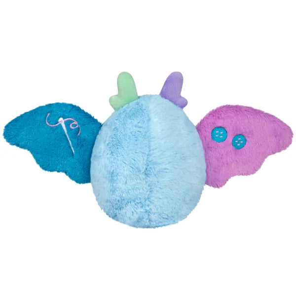 Squishable Alter Egos Series 21 Quilted Mothman plush with sky blue fur, mismatched antennae, and patchwork quilted wings.